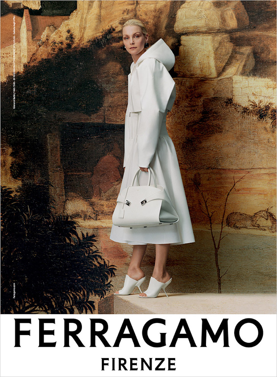 Modelka Jessica Stam ubrana w białą sukienkę, kurtkę i białe szpilki z białą torebką w ręku. Zdjęcie z kampanii Ferragamo AW2023.